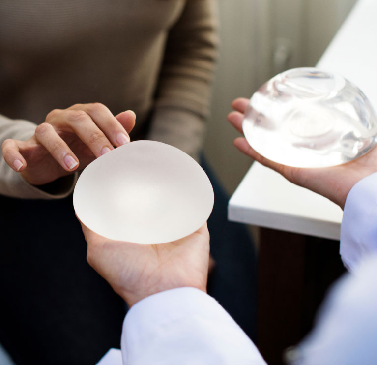 mishawaka plastic surgeon holding breast implants