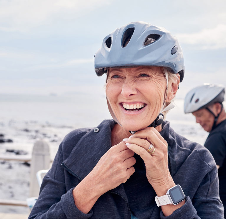 mishawaka woman enjoying a break in bike riding to adjust helmet