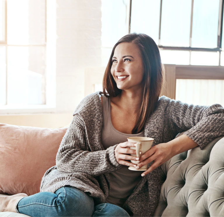 mishawaka woman in gray sweater enjoying coffee on a couch
