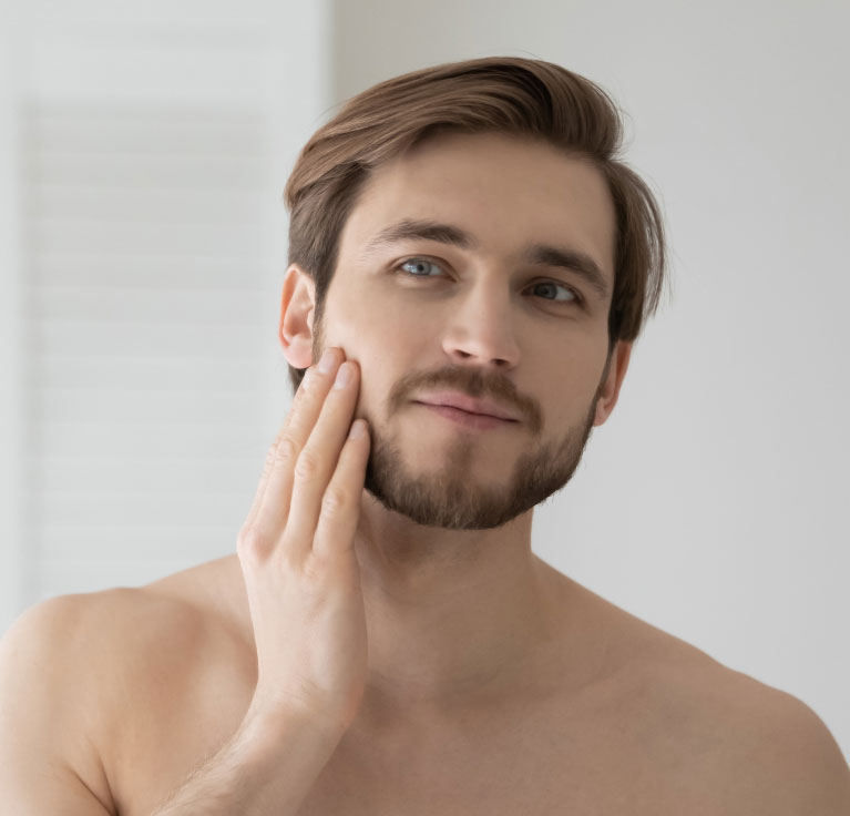 guy checking out his facial skin in mirror