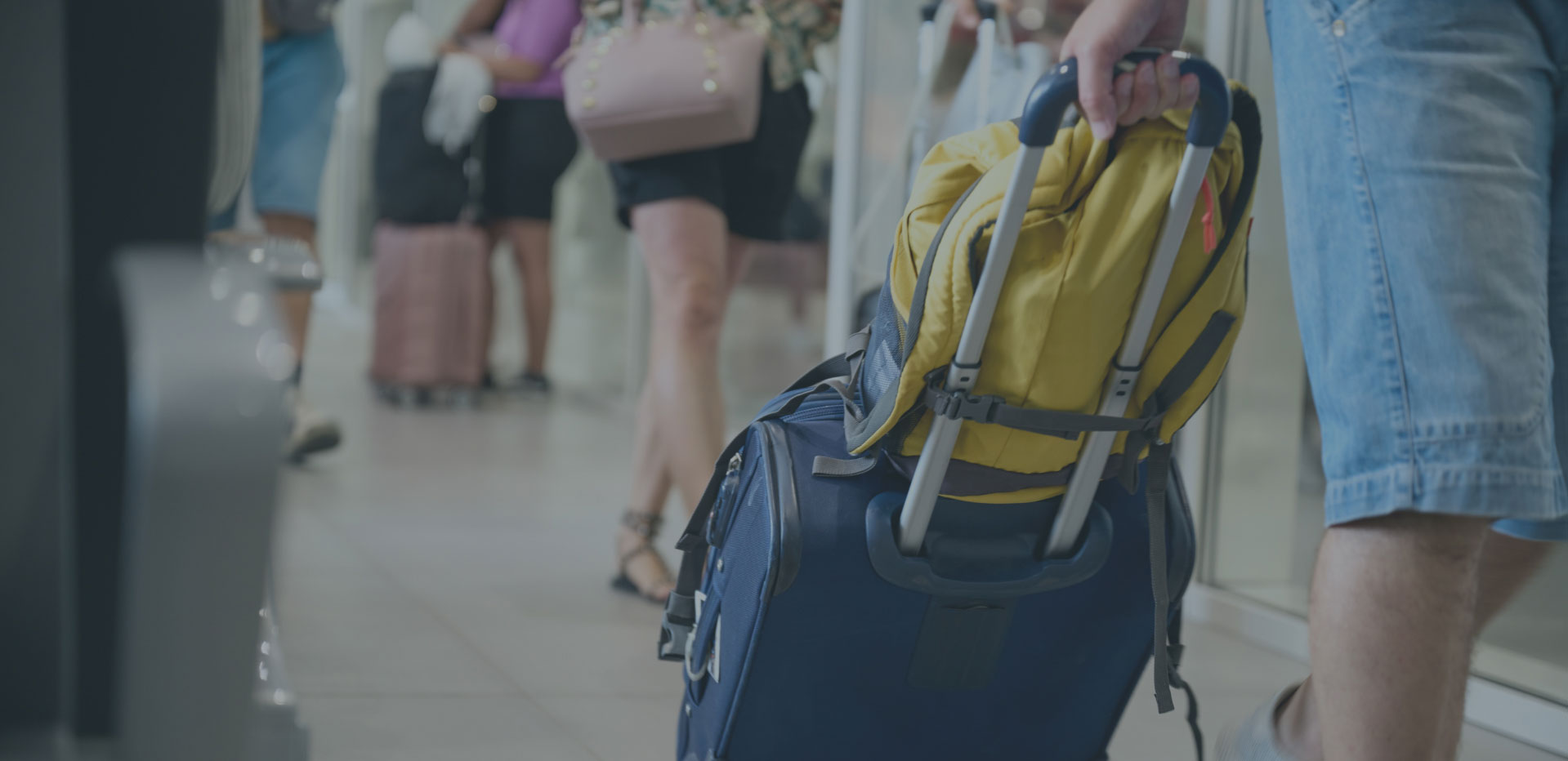roller suit case being walked through busy walkway